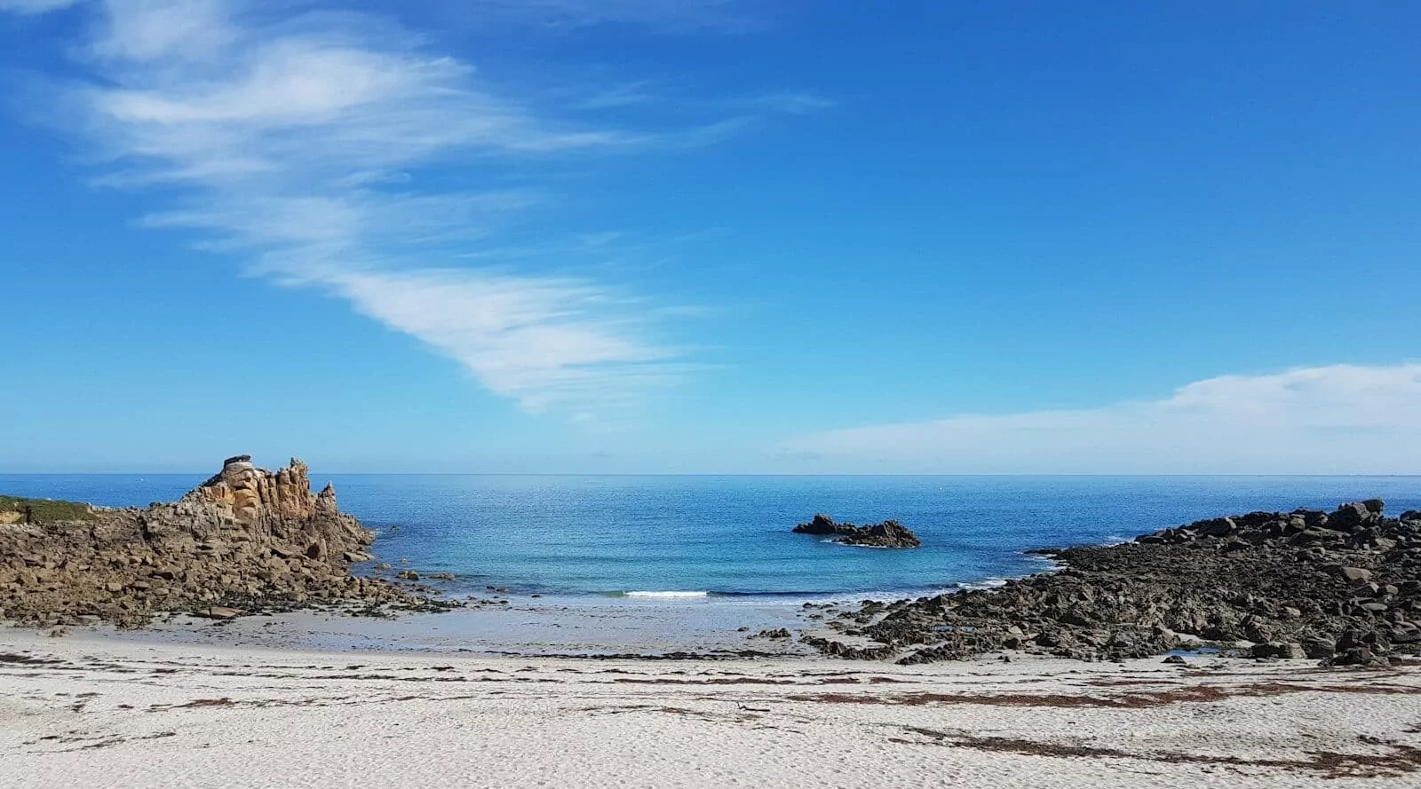 Photo by Muriel GARGRE a sandy beach next to the ocean under a blue sky